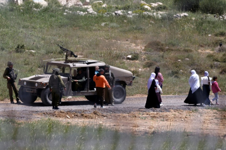 Israeli soldiers stop a Syrian Druze family, who fled sectarian violence outside Damascus, from crossing the buffer zone that used to separate Israeli and Syrian forces on Golan Heights.