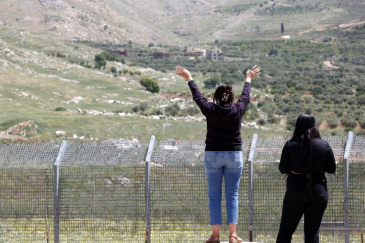 Syrian Druze in the Israeli-annexed Golan Heights wave to relatives who have sought refuge from the sectarian violence outside Damascus in the formerly demilitarised buffer zone, now under Israeli control.