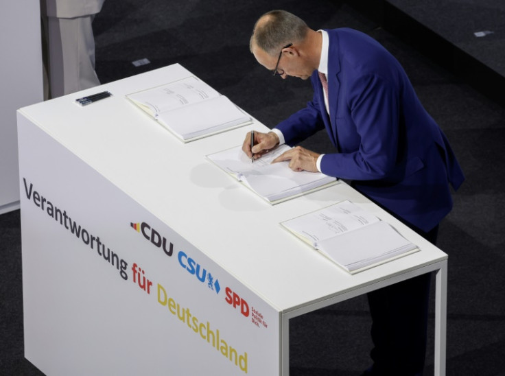 The leader of Germany's conservative Christian Democratic Union (CDU) party and designated chancellor, Friedrich Merz, signs the coalition deal to form the country's new government