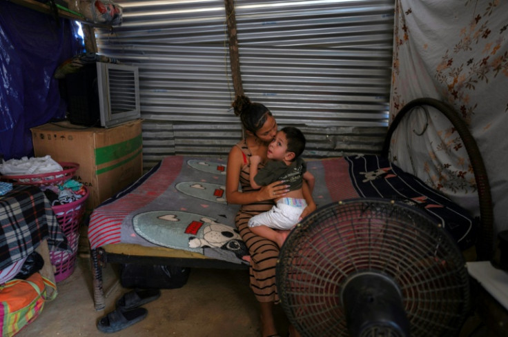 Venezuelan Astrid kisses her son Luis at their home in La Pista migrant camp in Maicao, La Guajira department, Colombia, on April 24, 2025