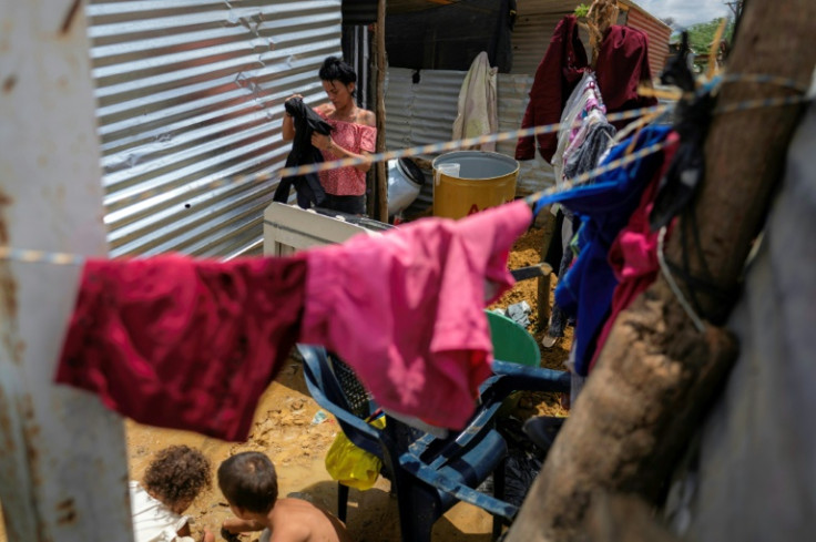 A Venezuelan migrant washes clothes at her home in the camp