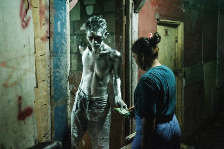 Keris Munandar hands over his tips to his wife Desi Apriyani, before bathing at their home in Jakarta