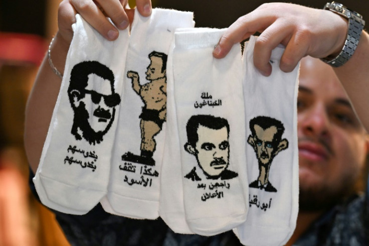 A vendor displays socks bearing caricatures of ousted Syrian leader Bashar al-Assad at his store in Damascus