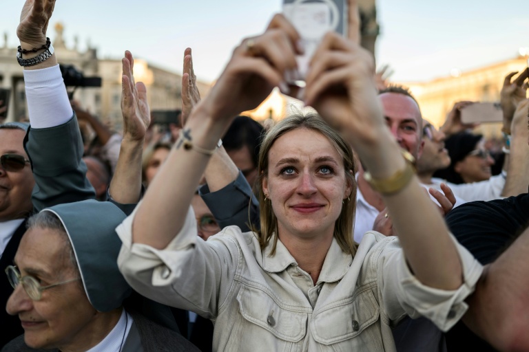 https://d.ibtimes.com/en/full/4599648/woman-uses-her-mobile-phone-snap-photos-newly-elected-pope-leo-xiv-vatican-first-pope-who.jpg