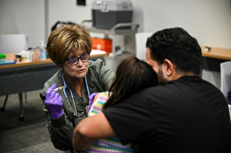 Administering the measles vaccine to a child at a health center in Lubbock, Texas