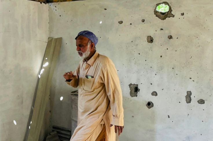 A resident is pictured inside his damaged house in Chakothi