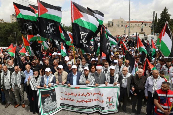 Palestinians wave national flags as they commemorate the 77th anniversary of the "Nakba" in the city of Ramallah