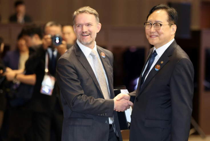 South Korean Trade Minister Cheong In-kyo (right) shakes hands with US trade representative Jamieson Greer before the opening ceremony of the Asia-Pacific Economic Cooperation 2025 Trade Ministers Meeting in Jeju