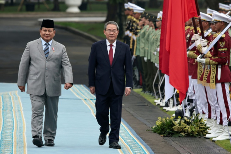 Indonesia's President Prabowo Subianto (L) and Chinese Premier Li Qiang inspect a guard of honour during a welcoming ceremony in Jakarta