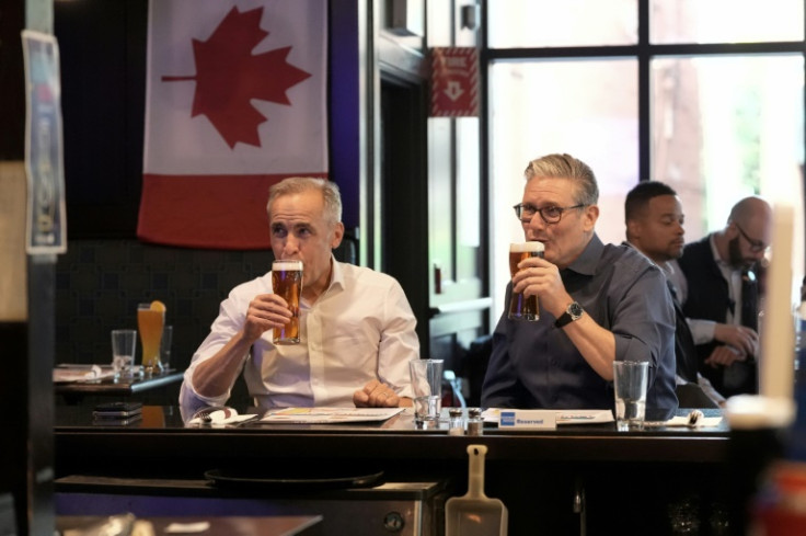 British Prime Minister Keir Starmer (R) and Canadian Prime Minister Mark Carney have a beer at the Royal Oak pub in Ottawa before they head to the Group of Seven summit