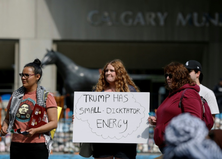 A protester holds a sign during a demonstration in front of Calgary City Hall on June 15, 2025, as world leaders converge in Canada for the G7 Summit