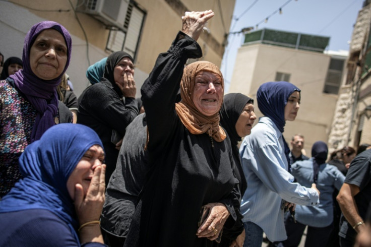 Mourners at a funeral for victims of an Iranian missile attack which destroyed a three-storey building in the northern city of Tamra