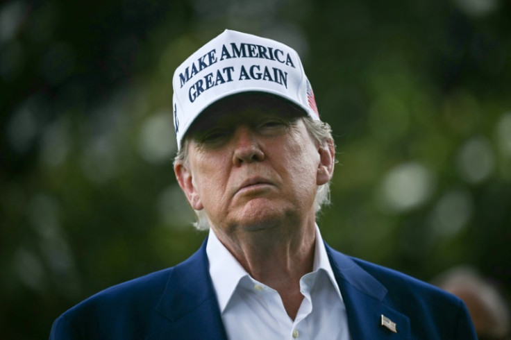 US President Donald Trump speaks to the press as workers install a large flag pole on the South Lawn of the White House in Washington, DC on June 18, 2025.