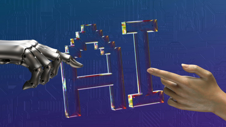Robot hand, human hand, and “AI” text