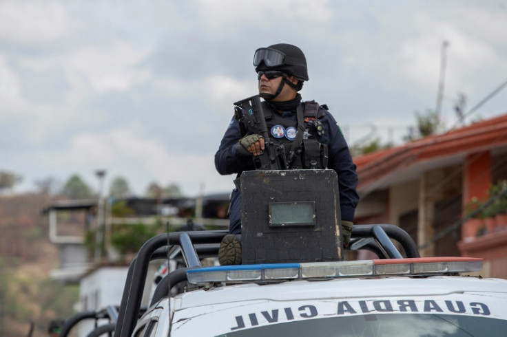 Un agent de la Garde nationale patrouille près de l'endroit où le maire de Tacambaro, Salvador Bastida, a éyé tué par des hommes armés avec son garde du corps à Tacambaro, dans l'Etat du Michoacan, dans l'ouest du Mexique, le 6 juin 2025.