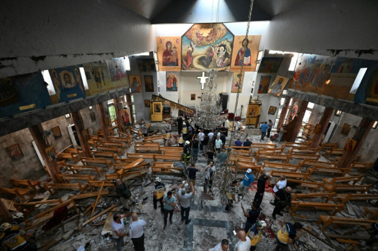 People inspect the damage at the site of a suspected suicide attack at the Saint Elias church in Damascus