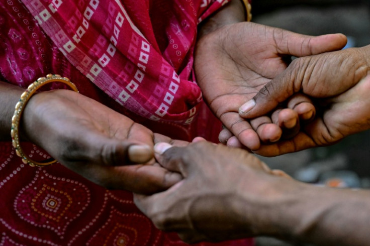 Jyoti Thorat (left), a sugarcane worker who was married as a child bride, prays with her husband, Ravindra, in their home at Kathoda village in Beed district of India's Maharashtra state