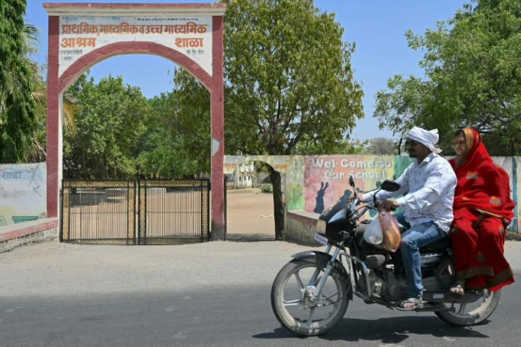 A couple ride past a hostel for children of sugarcane workers in Umrad Khalsa village, Maharashtra. India accounts for one in three of the world's child brides, according to the UN children's agency