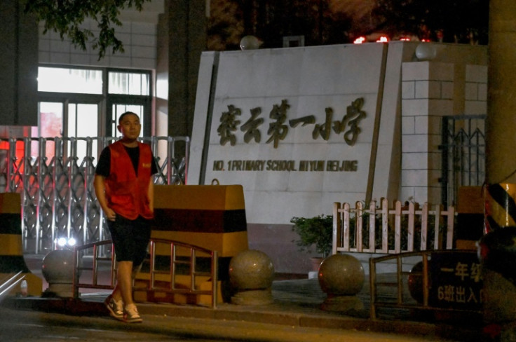 A man walks past the No.1 Primary School near where a crash incident occurred in Miyun, north of Beijing