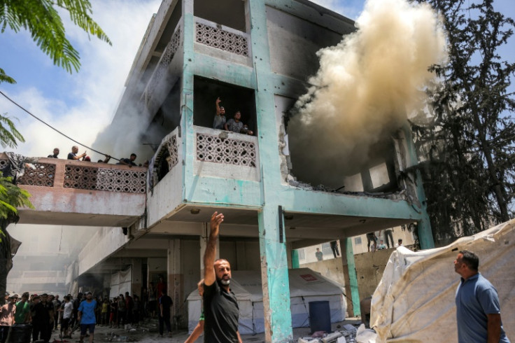 First-responders attempt to extinguish a blaze at Osama Bin Zaid school following an Israeli strike in the Saftawi district in western Jabalia