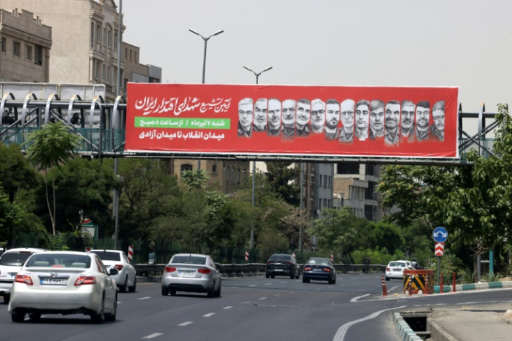 A banner bearing pictures of Iranian senior military officials killed in recent Israeli attacks hangs across a bridge in Tehran
