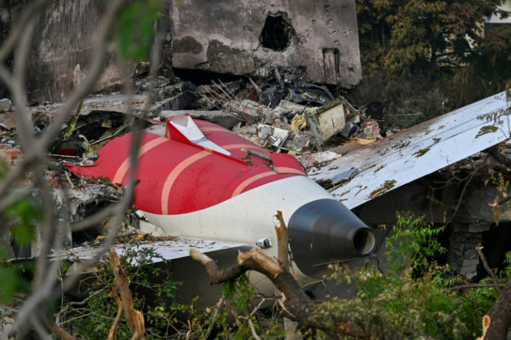 The tail section of the crashed Air India Boeing protruding from a building near the airport in Ahmedabad. Officials say the final death toll from the accident was 260