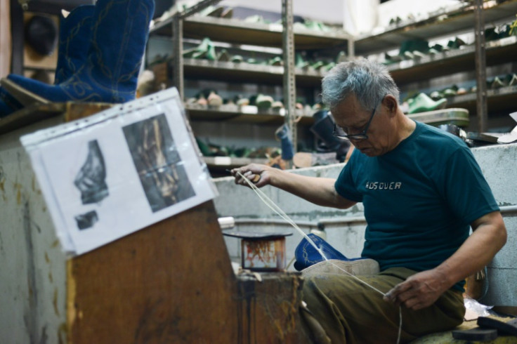 An artisan works on a pair of leather boots at the workshop of Tegep Boots in Bandung, West Java