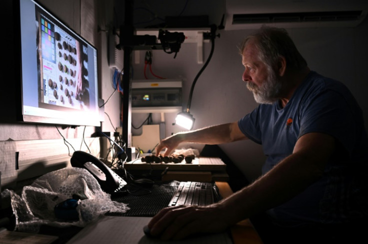 Geologist John McIntyre inspects polymetallic nodules onboard Moana Minerals' research vessel MV Anuanua Moana, which is exploring the far-flung South Pacific