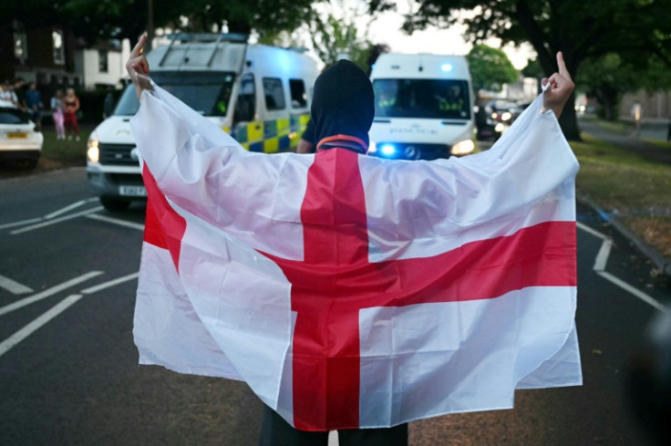A protester wrapped in the St George flag of England during anti-migrant protests in Epping, Essex, this month