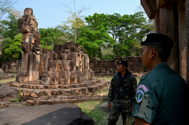 A Cambodian soldier (R) and Thai soldier stand guard at a disputed ancient Khmer temple on the Cambodian-Thai border in Oddar Meanchey province on March 26, 2025