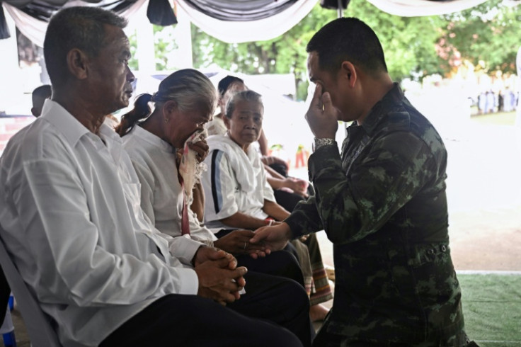 A soldier consoles the parents of Thai soldier Theerayuth Krajangthong, 22, who died in clashes with Cambodia, during funeral rites
