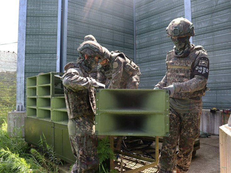 A handout photo taken on August 4 provided by the South Korean Defence Ministry shows soldiers removing loudspeakers at an undisclosed location in the DMZ