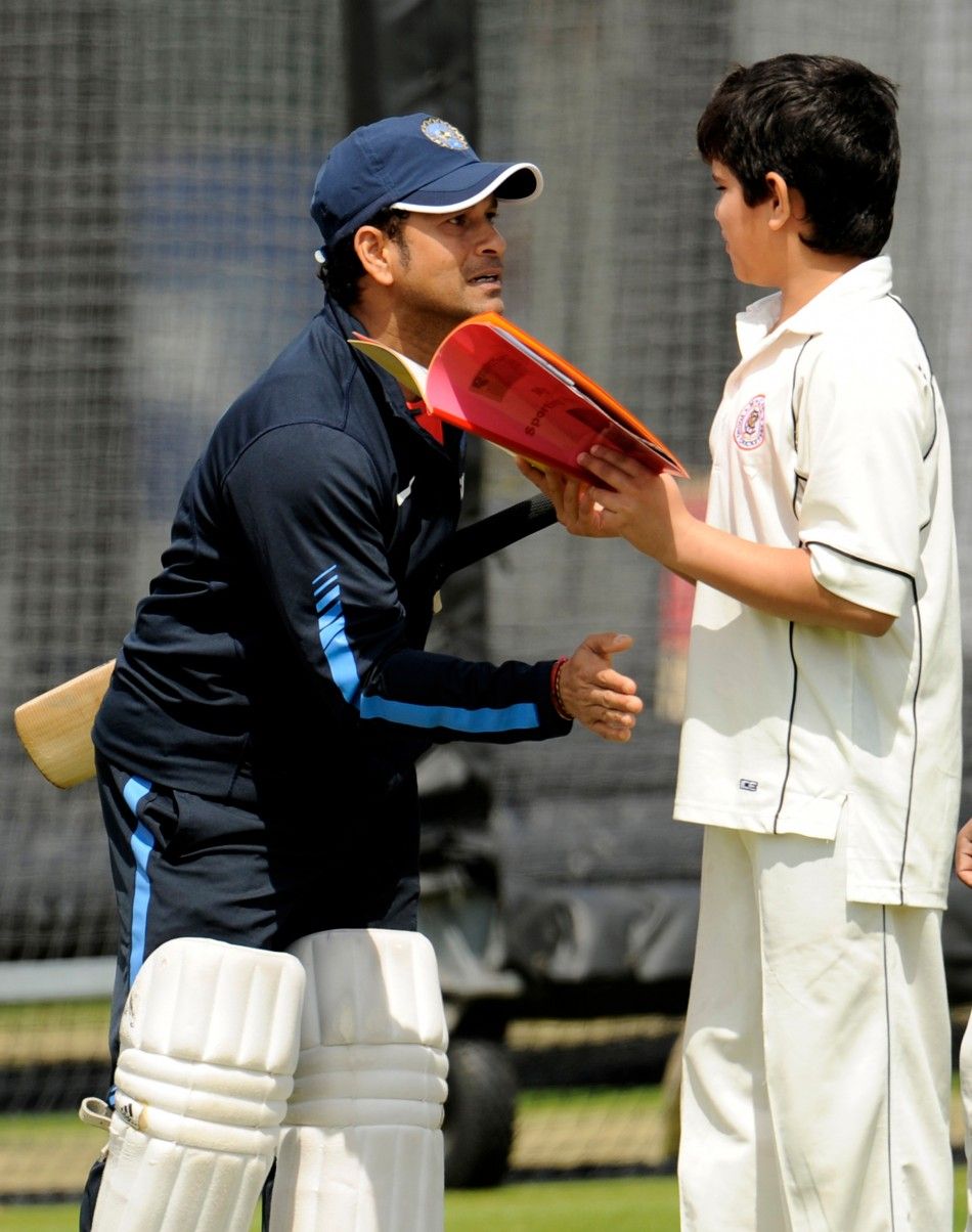 India039s Tendulkar pats his son Arjun during a training session before Thursday039s first cricket test match against England at Lord039s cricket ground in London.