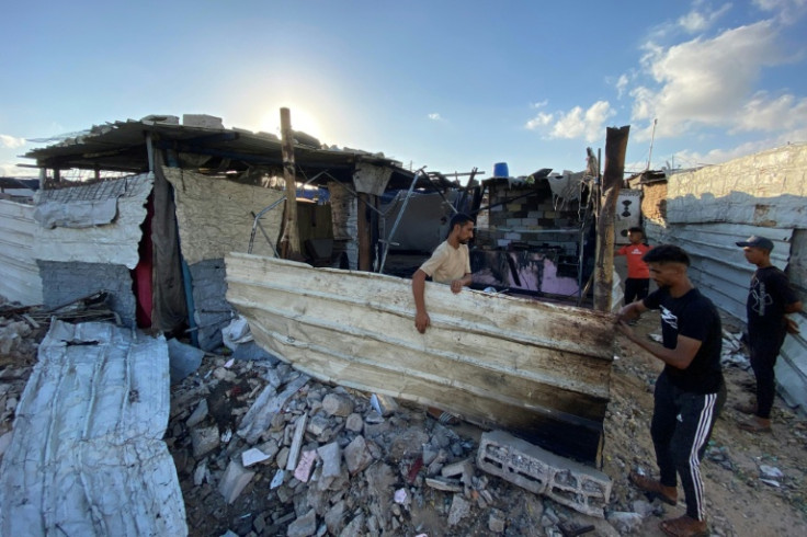 Palestinians recover what they can from the debris of an Israeli strike on the makeshift camp in Mawasi.