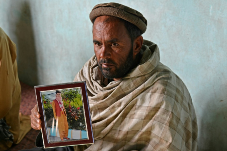 In this photograph taken in December 2021, Gul Ajan Hotak shows a picture of his son Shafiullah Hotak, who died after falling from a US Air Force C-17 aircraft