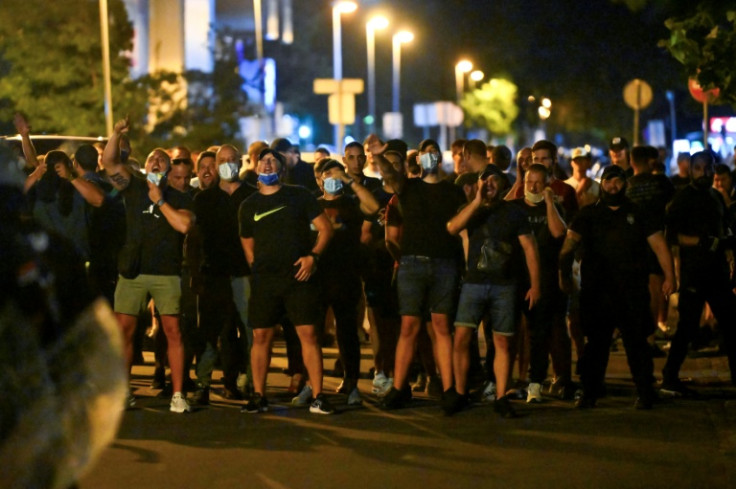 Supporters of the ruling Serbian Progressive party (SNS) stand in front of their party headquarters, opposing anti-government protesters in Belgrade.