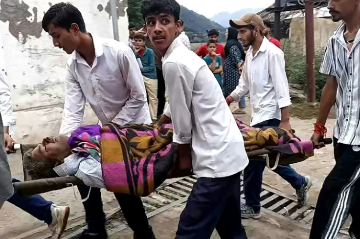 Crowds gathered at a Kishtwar hospital while people carried some of the injured on stretchers