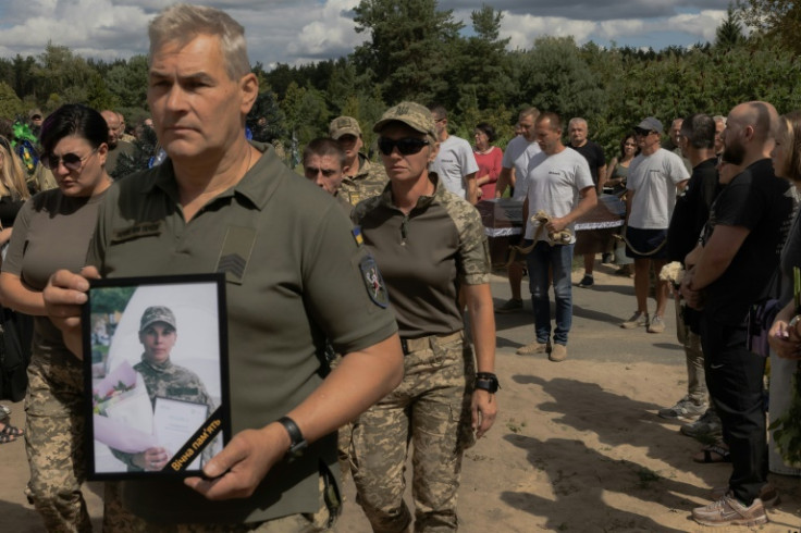 A Ukrainian military member carries a portrait of late Ukrainian soldier of the Unmanned Systems "Achilles" Regiment Nataliia Ilnytska, who was killed by artillery shelling in the Donetsk region fighting Russian troops, during her funeral ceremony in Irpi