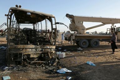 A crane prepares to tow the wreckage of a bus at the site of a crash in Guzara district of Herat province on August 20, 2025. The death toll from a collision between a bus carrying Afghan migrants returning from Iran and two other vehicles in western Afgh
