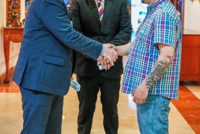 US Senator Chris Van Hollen (L) shaking hands with Salvadoran migrant Kilmar Abrego Garcia (R), a US resident wrongfully deported to his home country, at a hotel in San Salvador