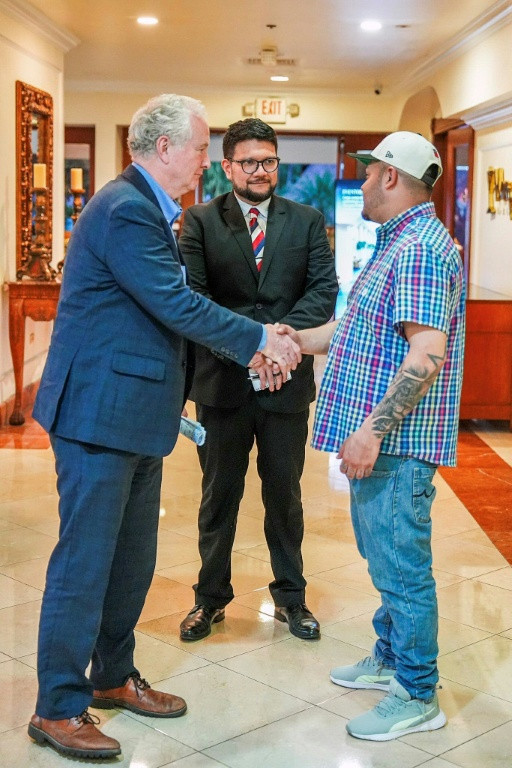 US Senator Chris Van Hollen (L) shaking hands with Salvadoran migrant Kilmar Abrego Garcia (R), a US resident wrongfully deported to his home country, at a hotel in San Salvador