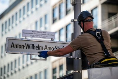A worker installs a sign with the street's new name, after years of controversy and a last-minute courtroom drama over the old name, 'Moors' Street'