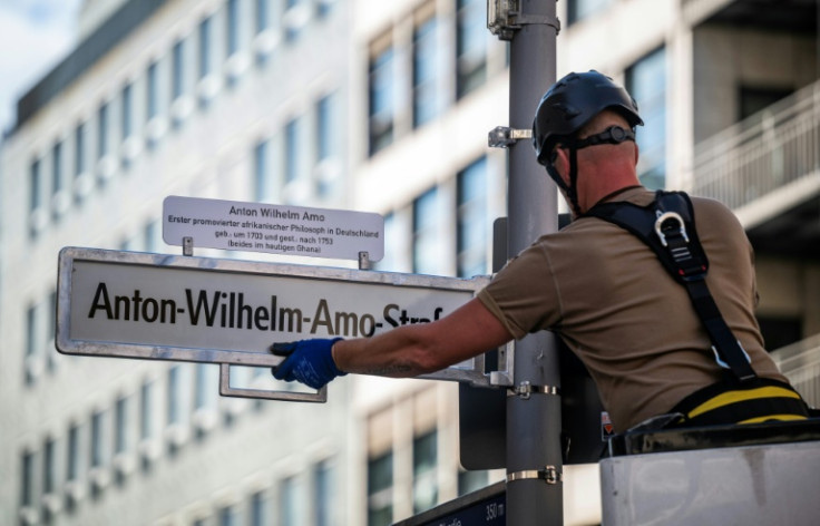 A worker installs a sign with the street's new name, after years of controversy and a last-minute courtroom drama over the old name, 'Moors' Street'