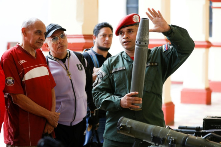 A member of the presidential guard shows weapons during an induction ceremony for volunteers