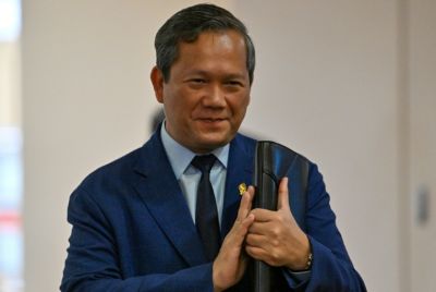 Cambodia’s Prime Minister Hun Manet greets people as he arrives to attend a meeting at the National Assembly building in Phnom Penh on August 25, 2025