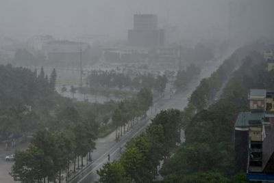 Rain falls above the buildings and a street in Vinh city on August 25, 2025, before Typhoon Kajiki makes landfall in Vietnam