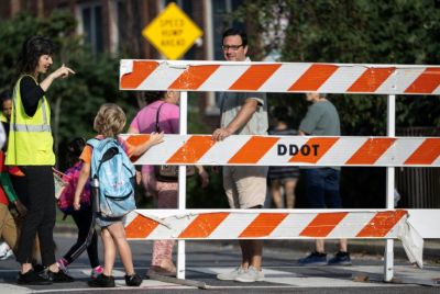 A staff member talks with a student on the first day of school in Washington