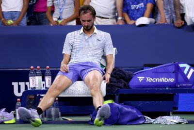 A dejected Daniil Medvedev sits on his chair after crashing out of the US Open first round following the latest in a long line of on-court meltdowns