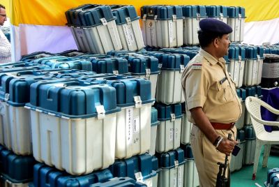 Police stand guard as officials check electronic voting machines and other materials ahead of assembly elections in India's Gujarat state