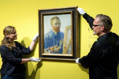 Staff at the Van Gogh Museum in Amsterdam hang a self-portrait of the artist